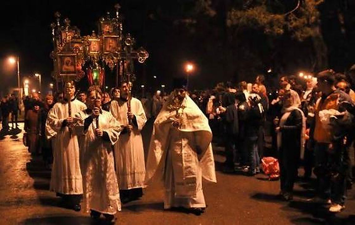 Clergy in white, carrying the light out