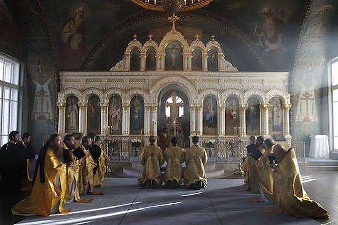 An iconostasis, and monks on the ground before it
